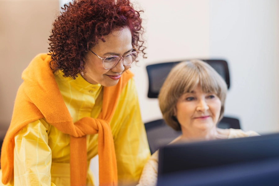 Two women by a computer.