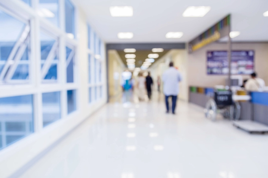 People walk down the hospital hallway.