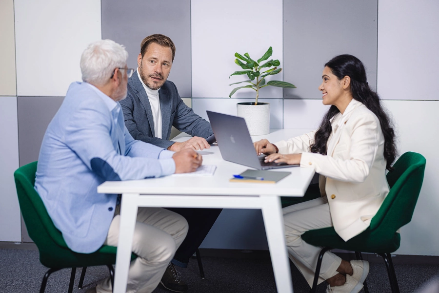 Three people discussing around a table