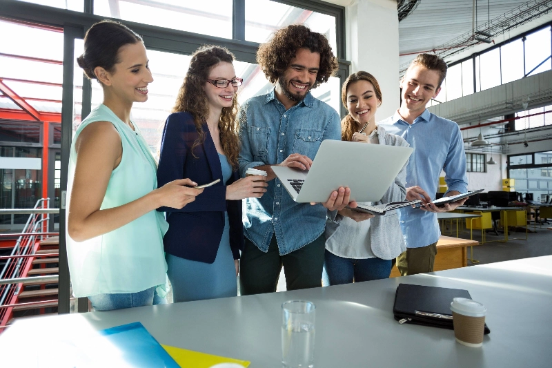 Five young people cooperating at the office  - Business Finland