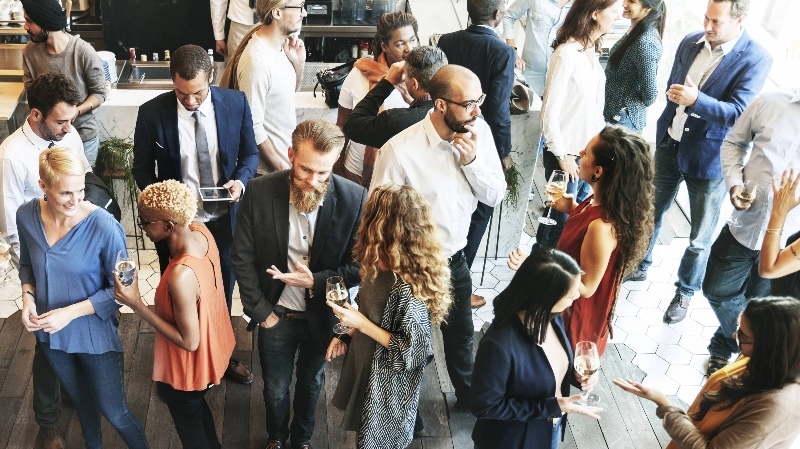 A group of people are standing and networking at an event