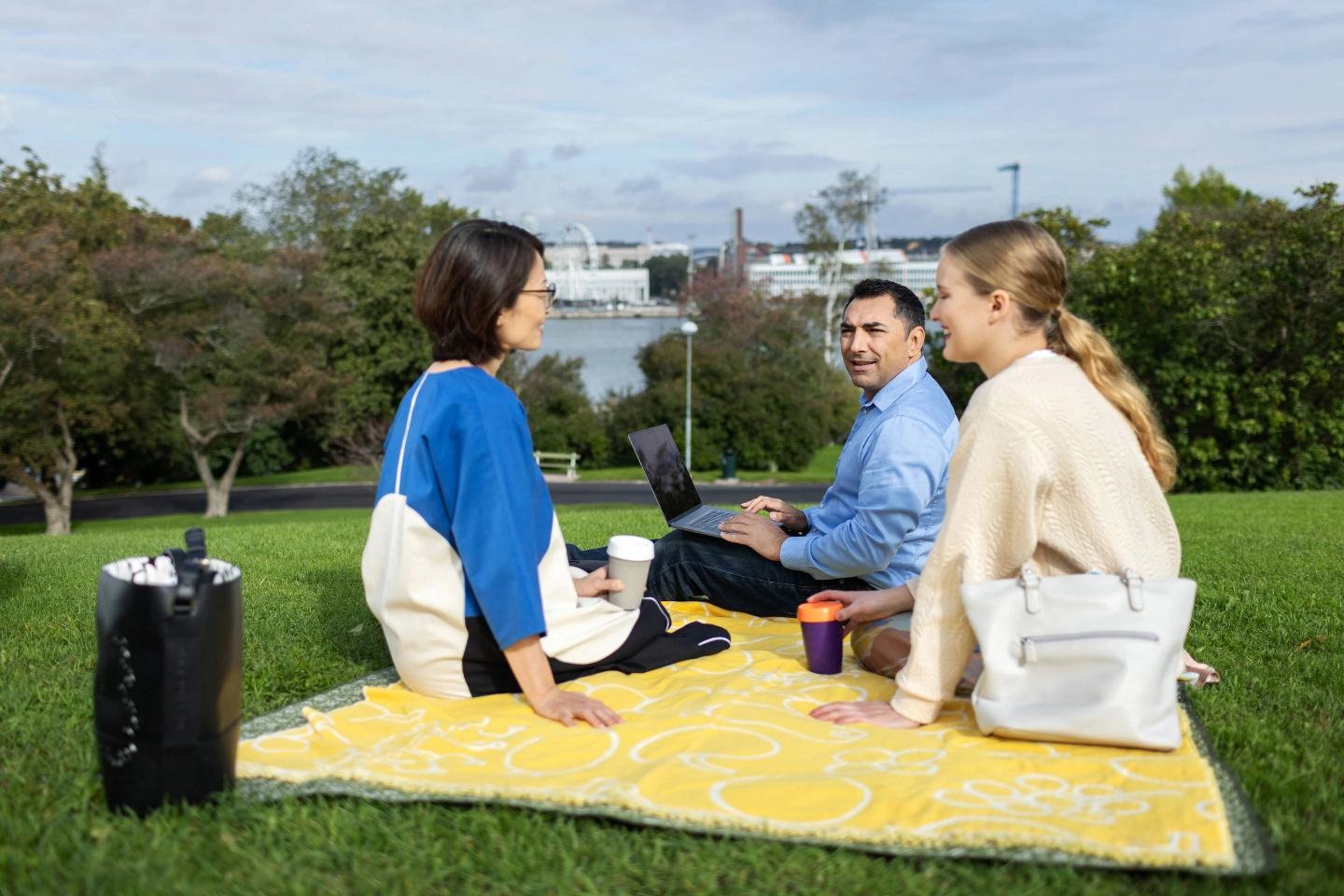 A group of people are sitting on the grass and talking. A group of people are sitting on the grass and talking.