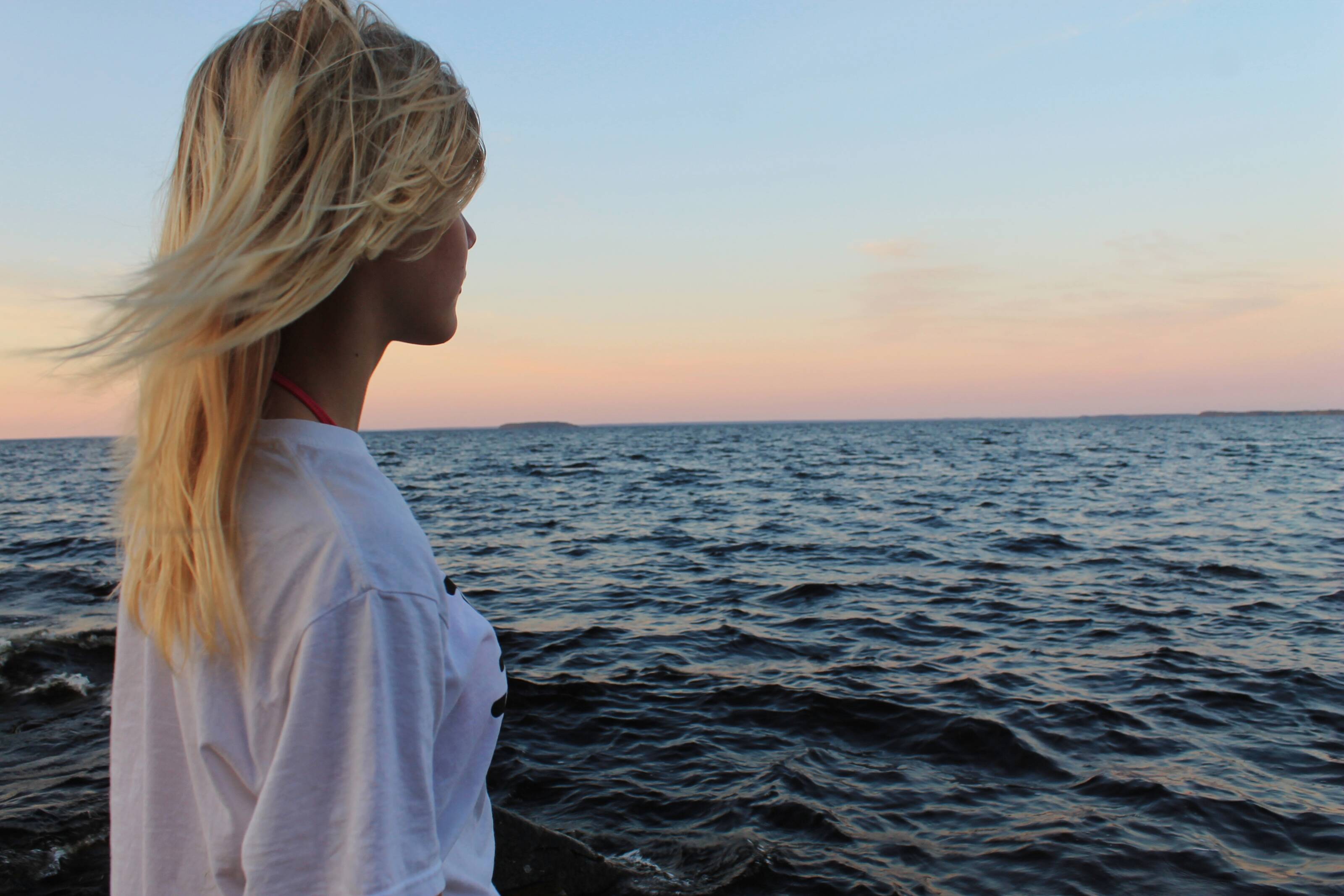 A woman staring at the lake Oulujärvi in Finland. - Pihla Peurasaari