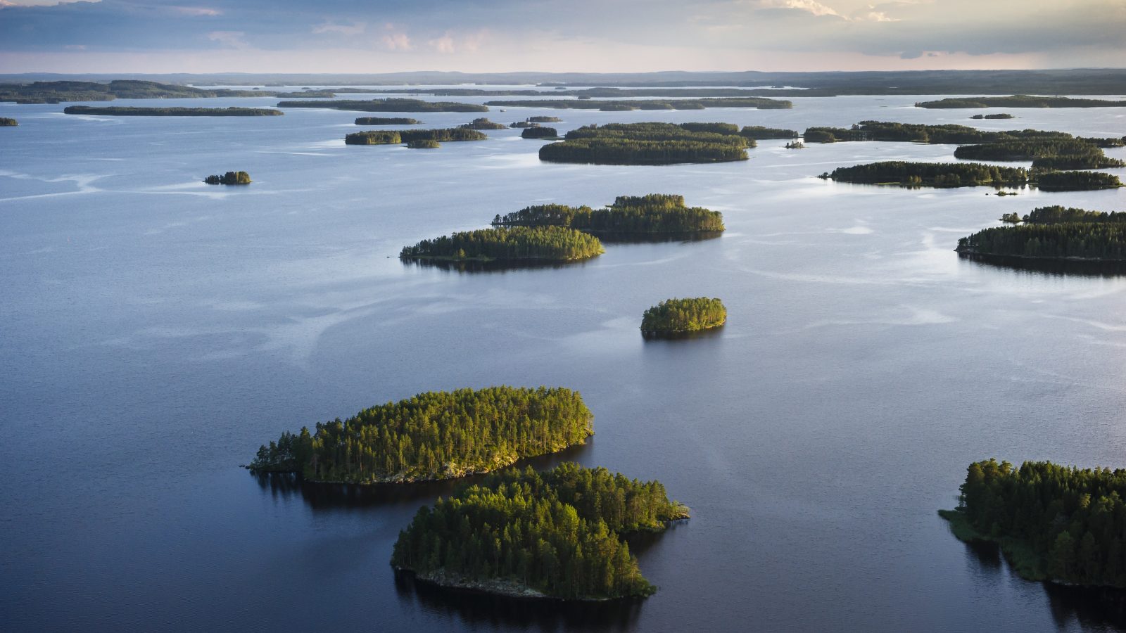 An aerial view over the lake full of small pine tree covered island in Finnish Lakeland.