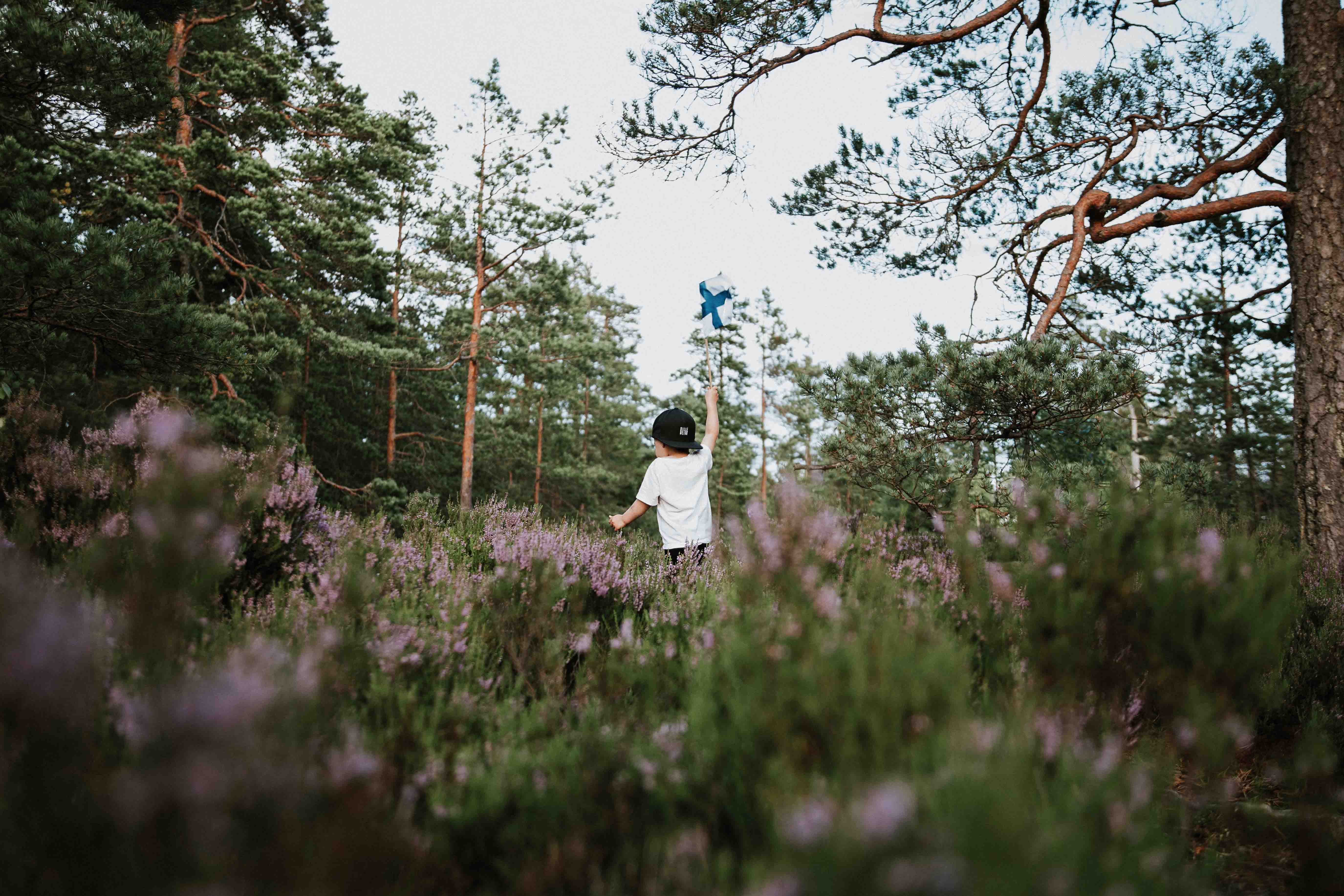 a kid with Finnish flag enjoying nature