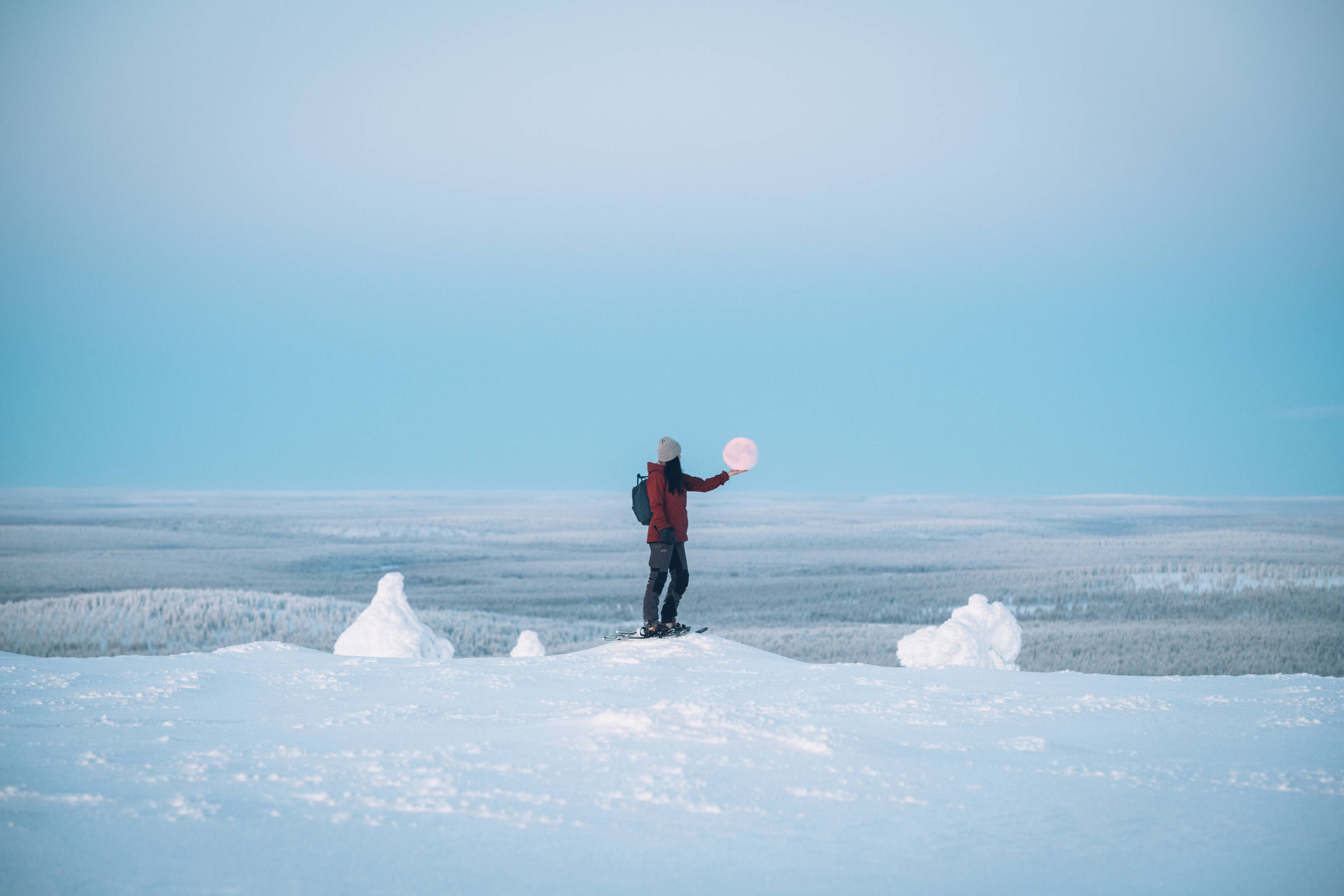 a skier posing with the moon on top of a fell