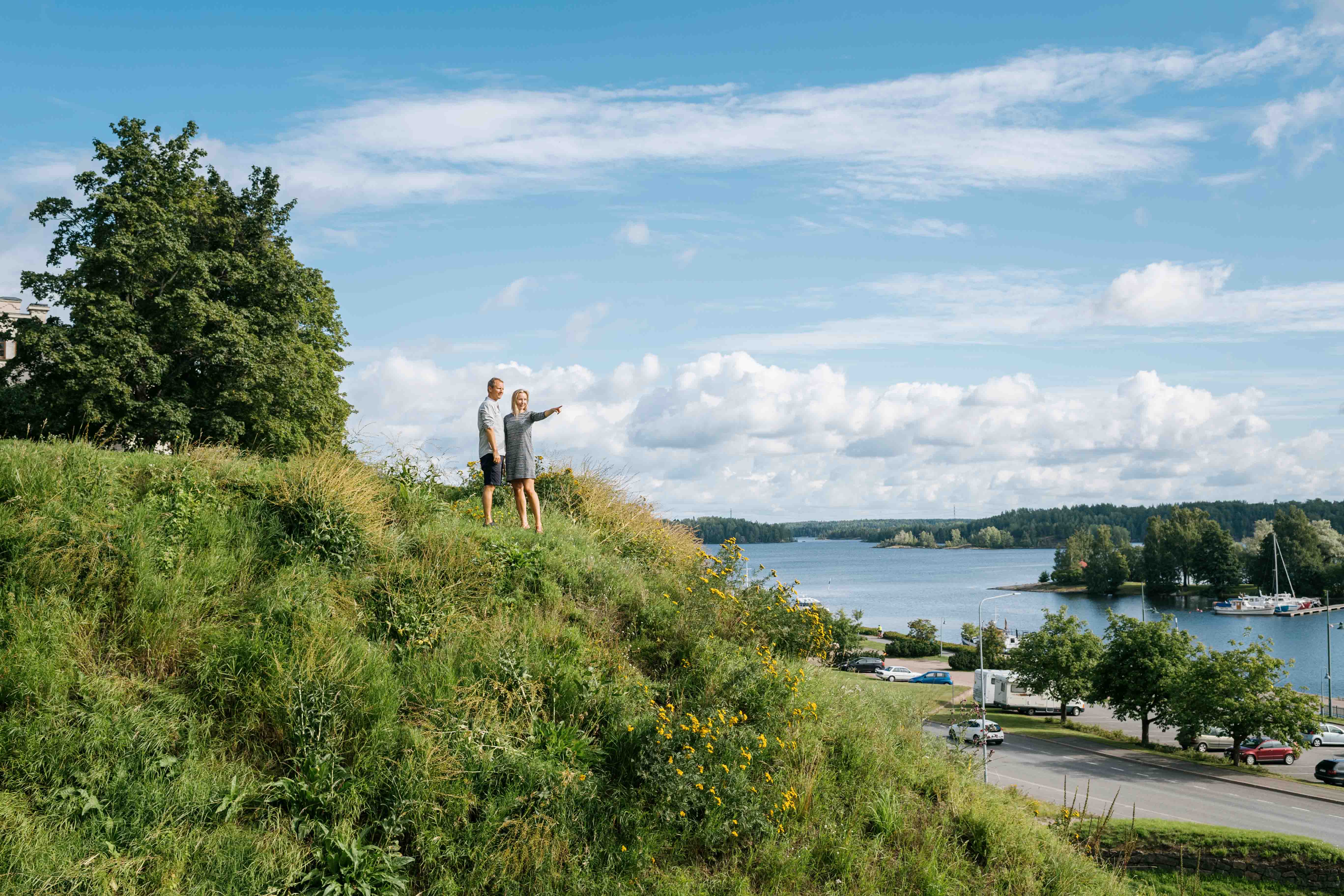 People standing on a hill by the lake.