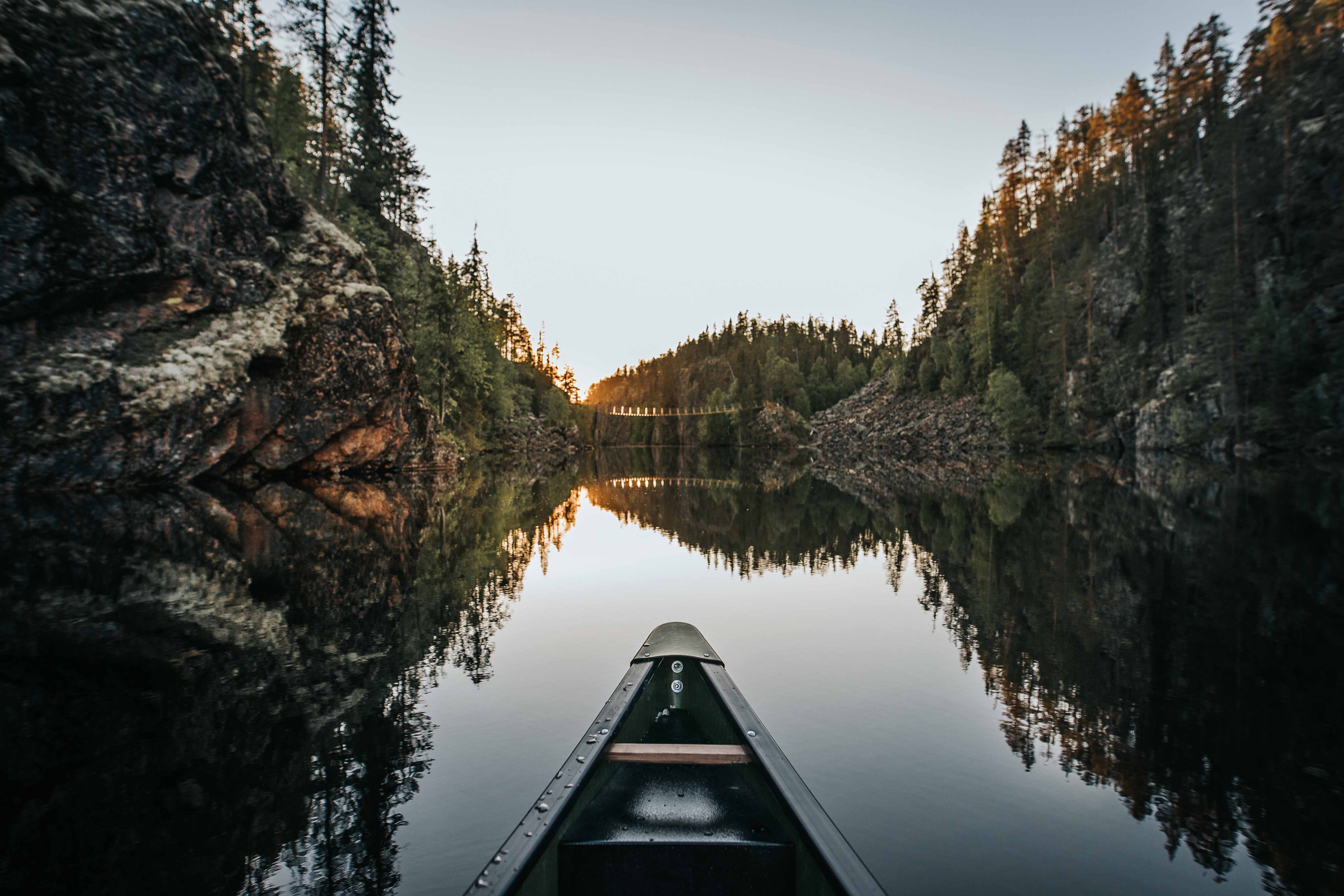 Ein Kajak durchquert einen engen Schluchtensee im finnischen Hossa-Nationalpark.