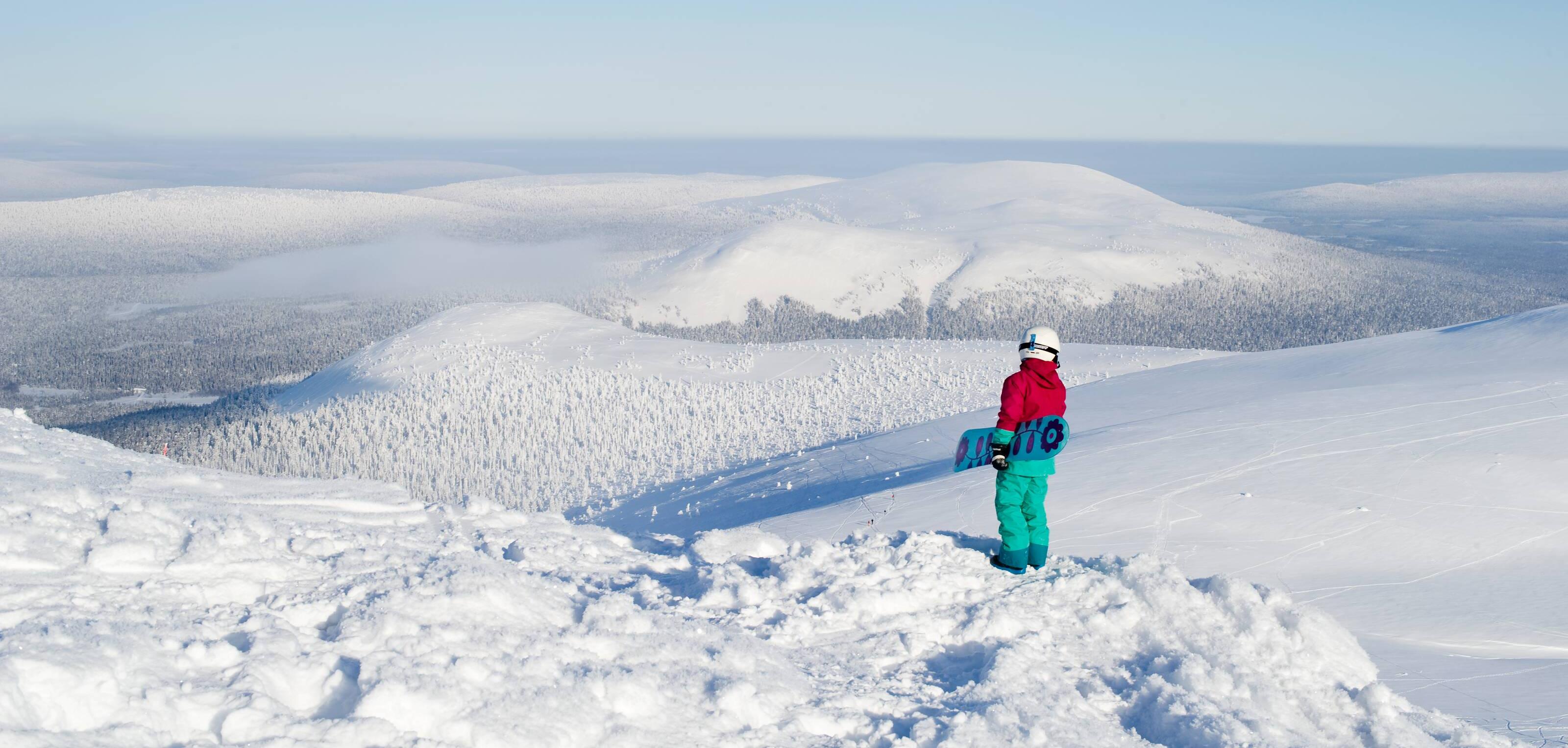 snowboarders admiring a snowy fell landscape