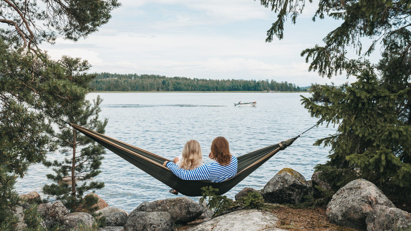 A woman and a man in a hammock staring at the Baltic sea.