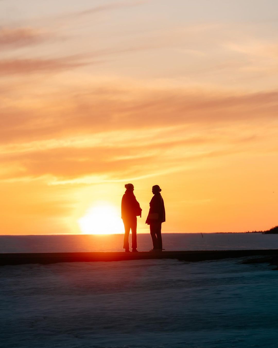 People during sunset at Nallikari beach in Oulu.