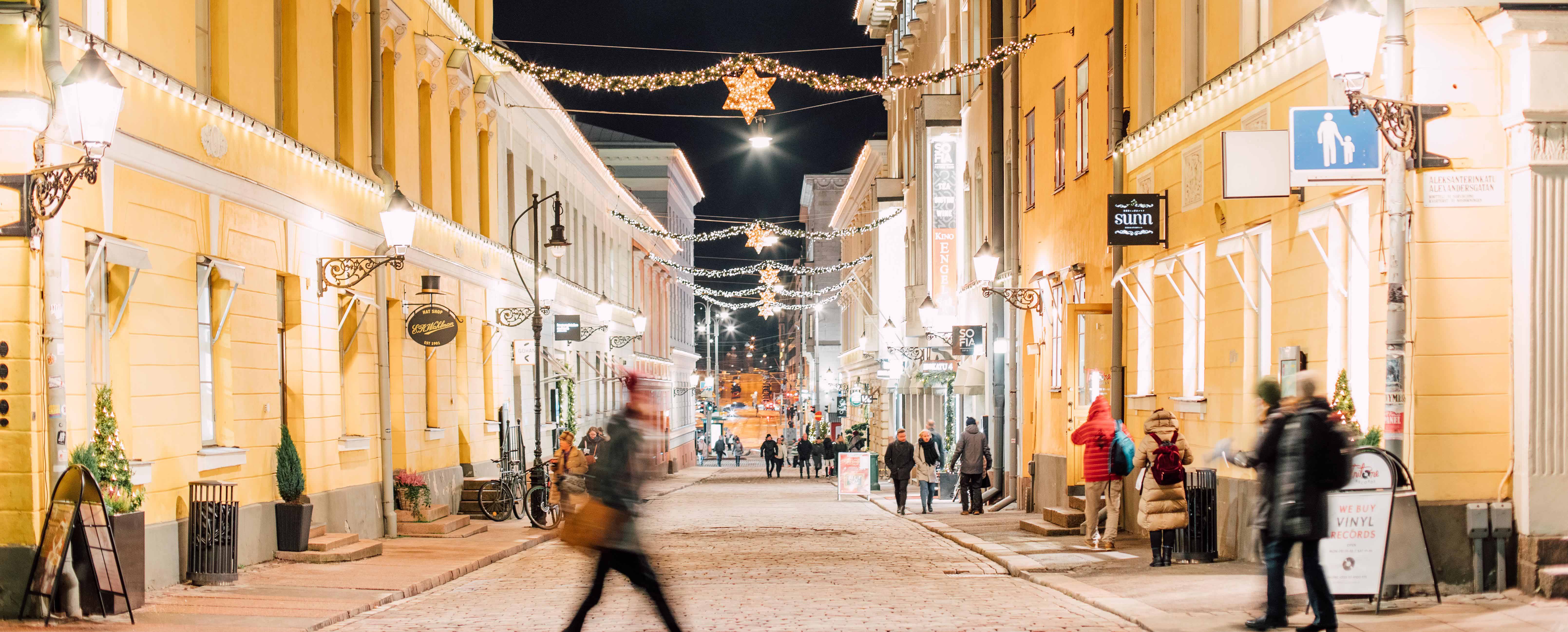 A street full of Christmas lights and people in Helsinki downtown at night.