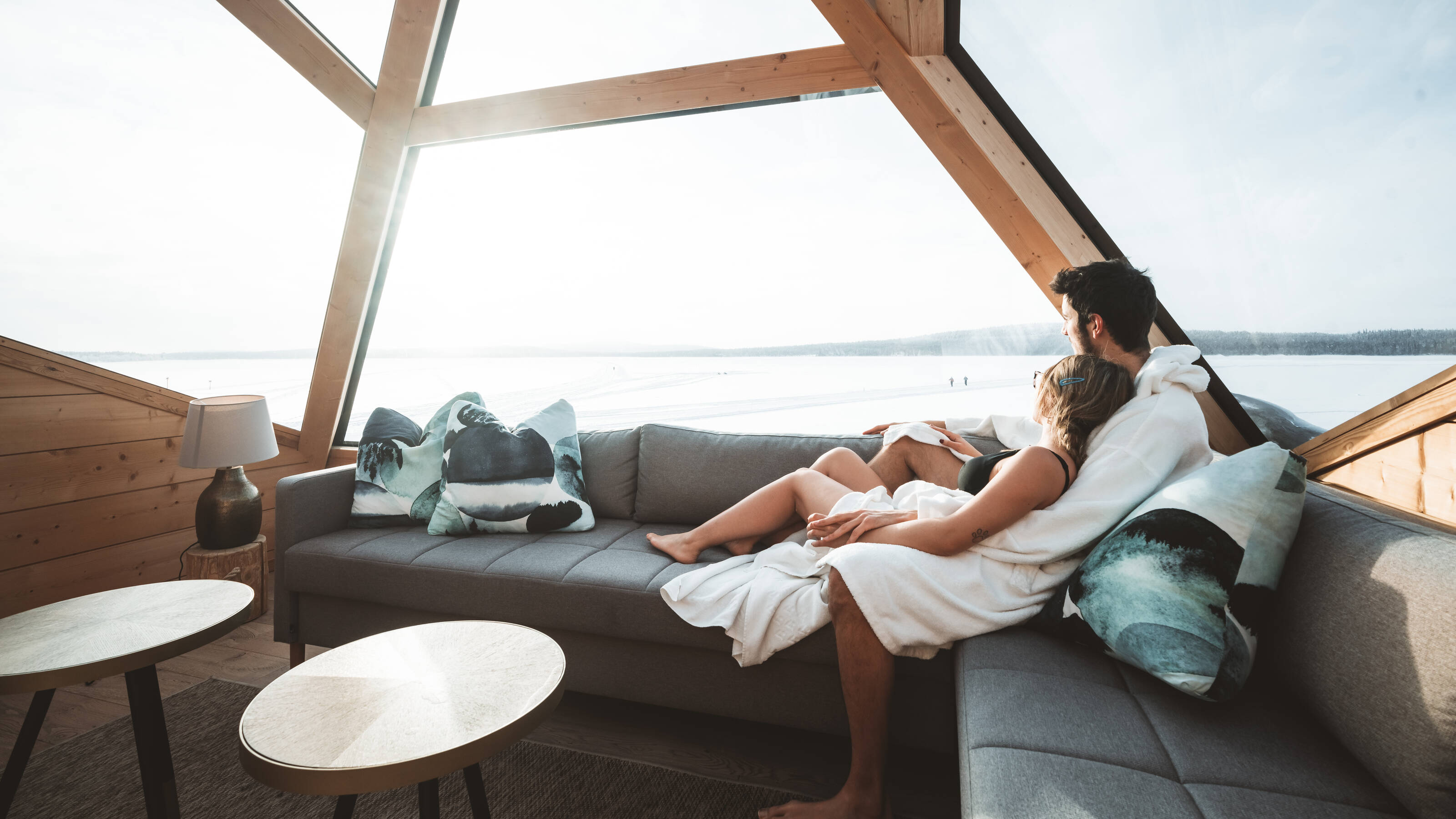 Two people relaxing at Arctic Sauna World in Lapland, Finland.
