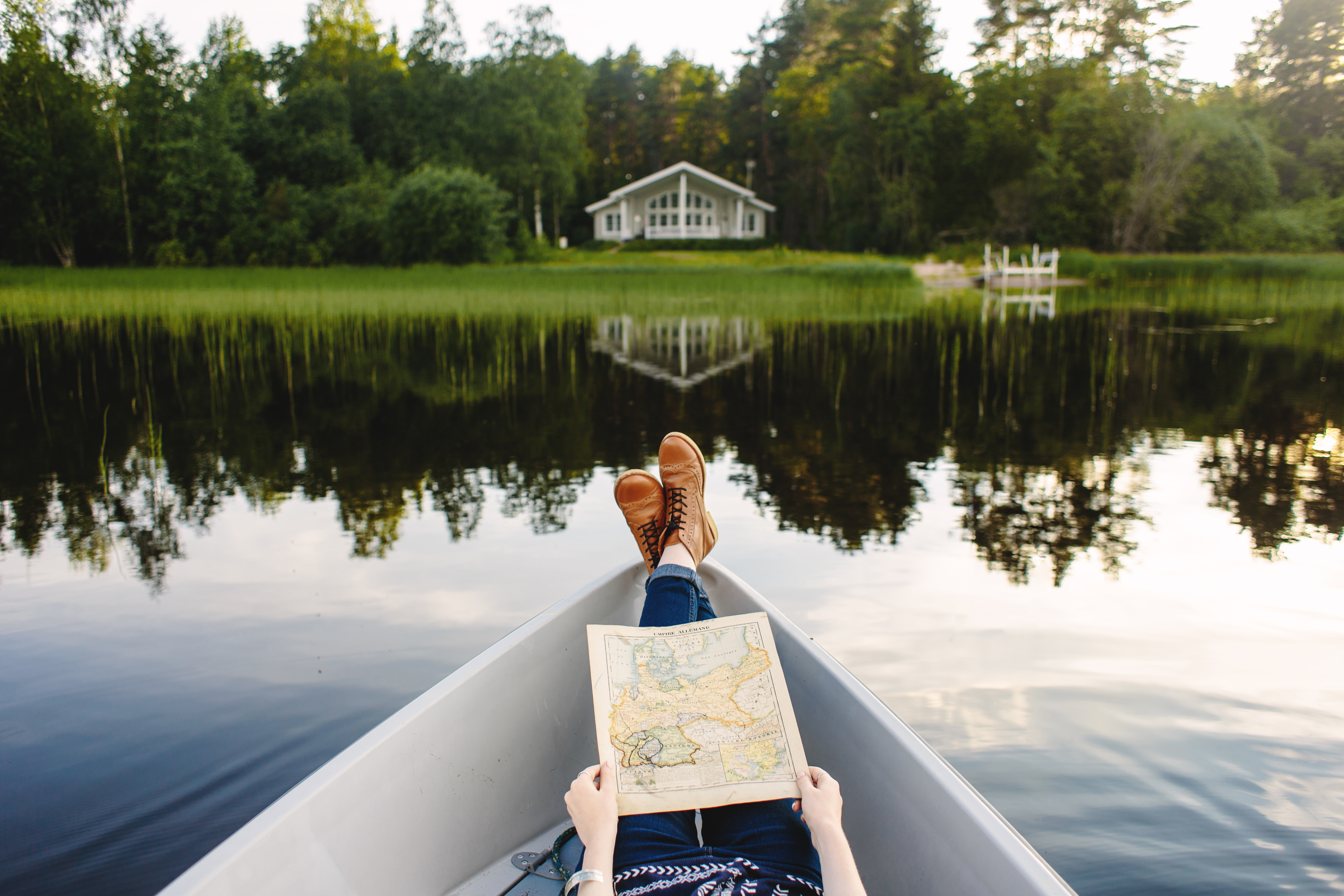 一个人躺在芬兰湖景前的船上