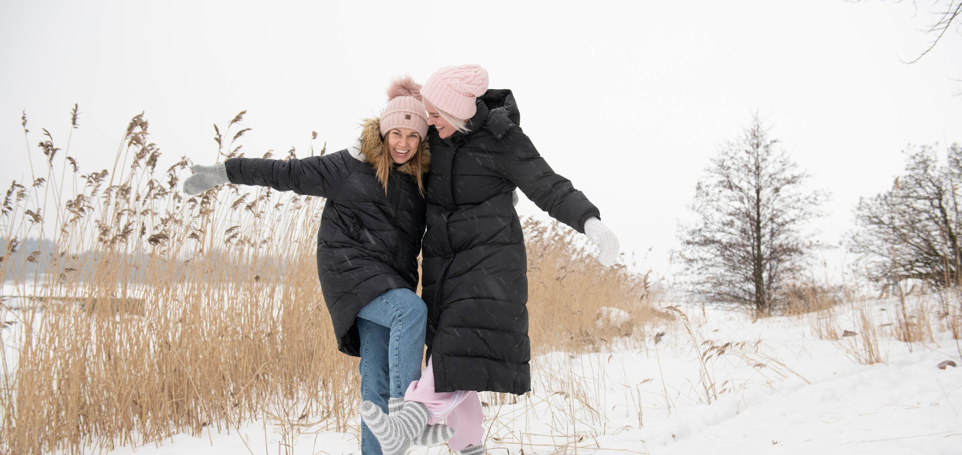 two happy women laughing in the snow