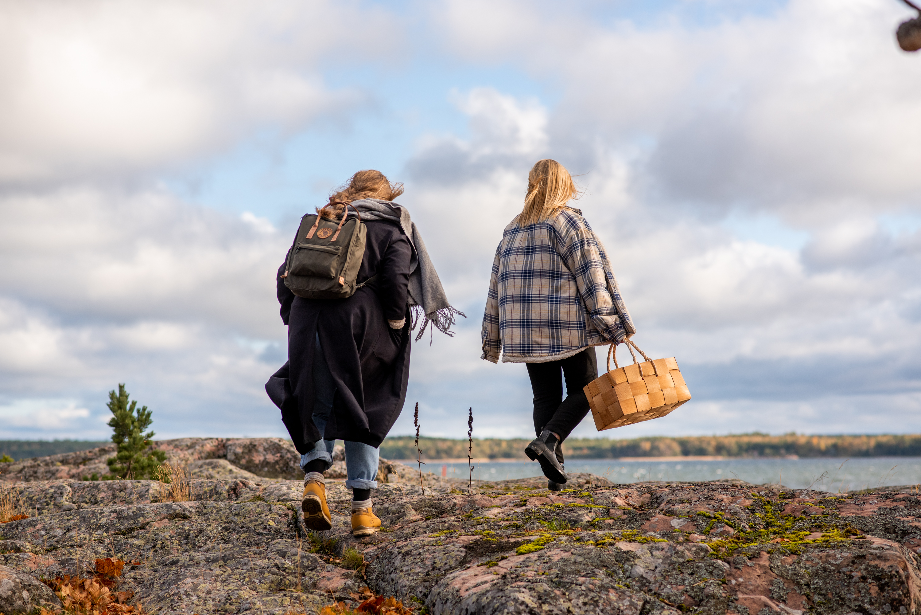 Två kvinnor som söker efter föda vid den finska kusten