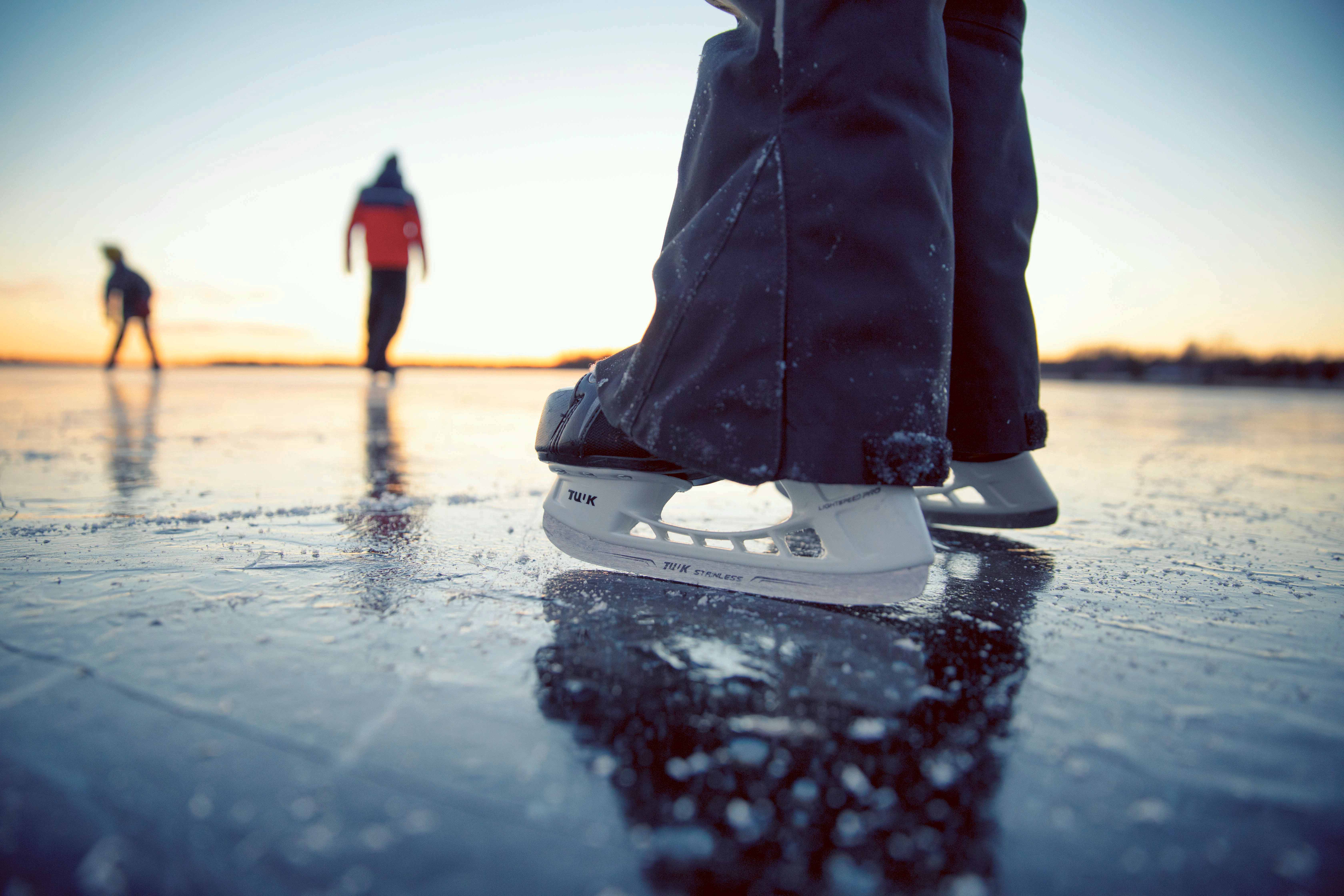 Close-up of a skater's skates on the ice of a lake.