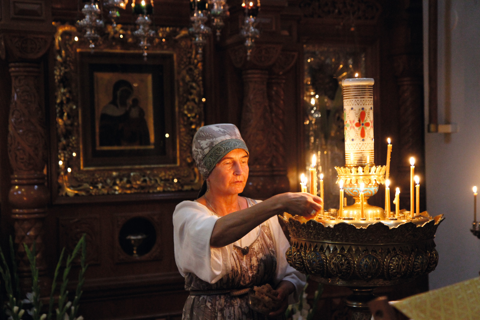 A person lights candles in Valamo Monastery. - Valamo Monastery